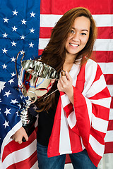 Image showing Sportswoman Holding Trophy Against North American Flag