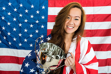 Image showing Beautiful Sportswoman Holding Trophy Against North American Flag