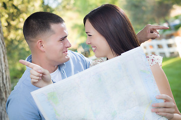 Image showing Lost and Confused Mixed Race Couple Looking Over Map Outside