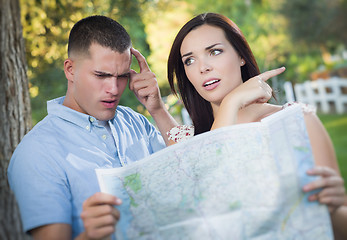 Image showing Lost and Confused Mixed Race Couple Looking Over Map Outside