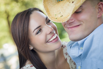 Image showing Mixed Race Romantic Couple with Cowboy Hat Flirting in Park