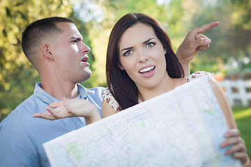 Image showing Lost and Confused Mixed Race Couple Looking Over Map Outside