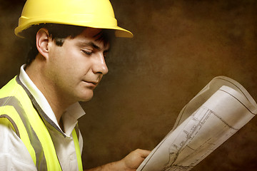 Image showing Male builder site foreman reading architectural industrial plans