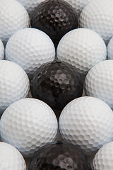 Image showing White and black golf balls and wooden tees