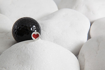 Image showing Black golf ball and red heart