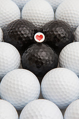 Image showing White and black golf balls and wooden tee