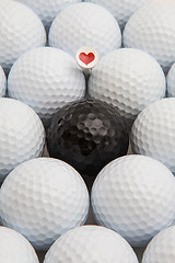 Image showing White and black golf balls and wooden tees