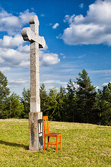 Image showing The stone cross and empty wooden chair