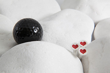 Image showing Black golf balls and wooden tees