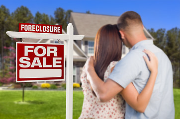 Image showing Military Couple Standing in Front of Foreclosure Sign and House