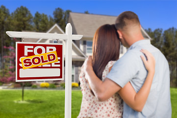 Image showing Sold For Sale Sign with Military Couple Looking at House