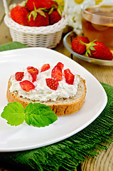 Image showing Bread with curd cream and strawberries on a board