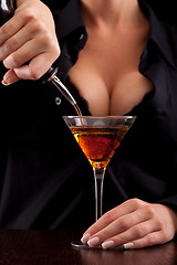 Image showing Barmaid mixing drink