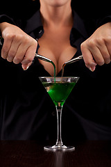 Image showing Barmaid mixing drink