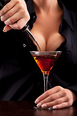 Image showing Barmaid mixing drink