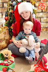 Image showing Young woman in a Santa hat and little boy.