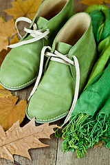 Image showing pair of green leather boots, scarf and yellow leaves