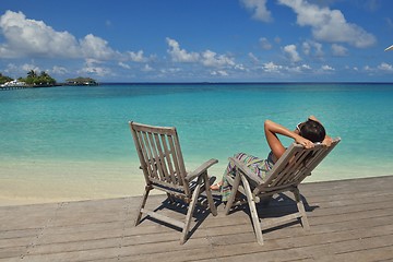 Image showing Beautiful young woman with a drink by the sea