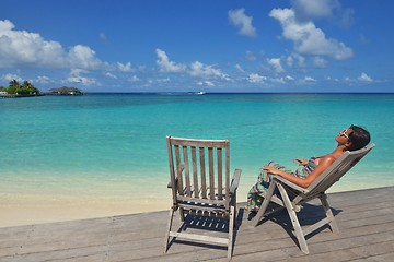 Image showing Beautiful young woman with a drink by the sea