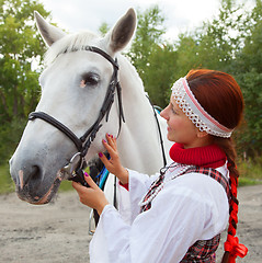Image showing The girl stroking horse