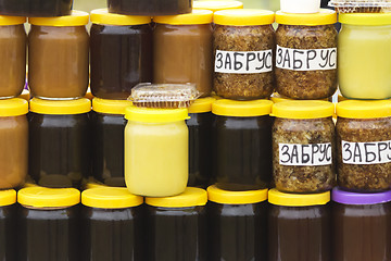 Image showing Different varieties of honey in banks, offered for sale at the f