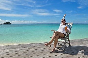 Image showing Beautiful young woman with a drink by the sea