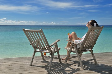 Image showing Beautiful young woman with a drink by the sea