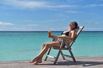 Image showing Beautiful young woman with a drink by the sea