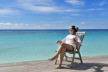 Image showing Beautiful young woman with a drink by the sea