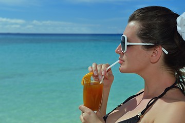 Image showing Beautiful young woman with a drink by the sea