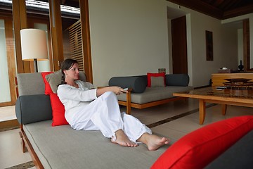 Image showing happy young woman relax at home on sofa