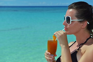 Image showing Beautiful young woman with a drink by the sea