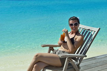 Image showing Beautiful young woman with a drink by the sea