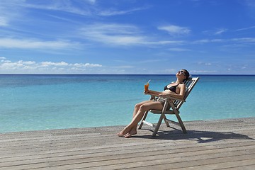Image showing Beautiful young woman with a drink by the sea