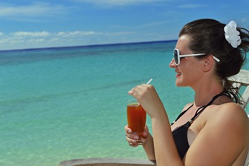 Image showing Beautiful young woman with a drink by the sea