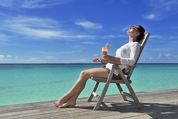 Image showing Beautiful young woman with a drink by the sea