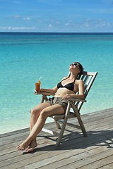 Image showing Beautiful young woman with a drink by the sea