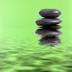 Image showing Spa massage stones in green water