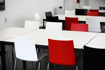 Image showing Empty red and white tables and chairs