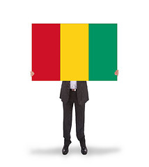 Image showing Businessman holding a big card, flag of Guinea