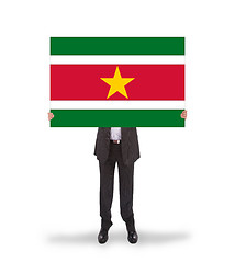 Image showing Businessman holding a big card, flag of Suriname