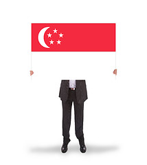 Image showing Businessman holding a big card, flag of Singapore