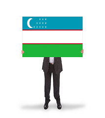 Image showing Businessman holding a big card, flag of Uzbekistan