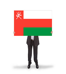 Image showing Businessman holding a big card, flag of Oman