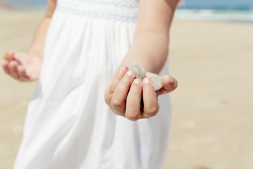 Image showing Girl on the beach holding stones