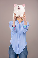 Image showing Beautiful woman holding  a piggy bank