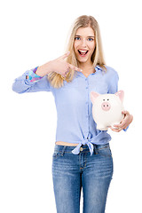 Image showing Woman pointing to a piggy bank