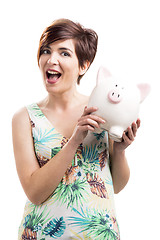 Image showing Admired woman with a piggy bank