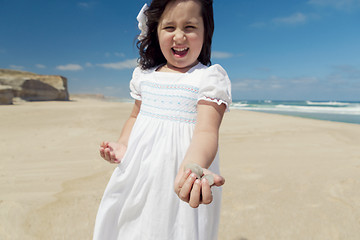 Image showing Girl on the beach holding stones