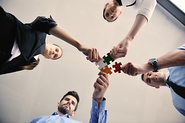 Image showing Group of business people assembling jigsaw puzzle